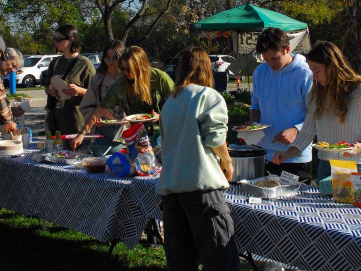 Students enjoy a potluck style meal during the harvest party.